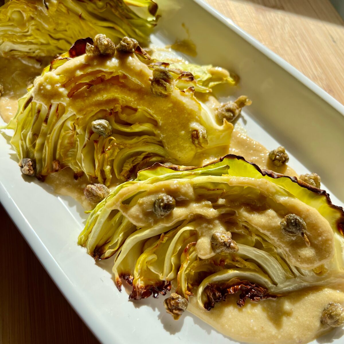 charred cabbage with anchovy almond sauce and fried capers